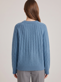Sweter damski oversize, widok z tyłu: prążkowany wzór, ściągacz u dołu i przy mankietach