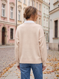 Kremowy kardigan damski na modelce, widok z tyłu: gładka dzianina i ściągacz u dołu