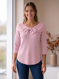 Różowy sweter damski prążkowany z kokardą przy dekolcie na modelce, rękaw 3/4, widok z przodu