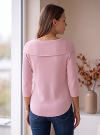 Różowy sweter damski prążkowany na modelce, widok z tyłu: szeroki wykładany kołnierz i zaokrąglony dół