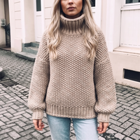 Sweter damski oversize z golfem w kolorze khaki na modelce, cała sylwetka, splot ryżowy i bufiaste rękawy
